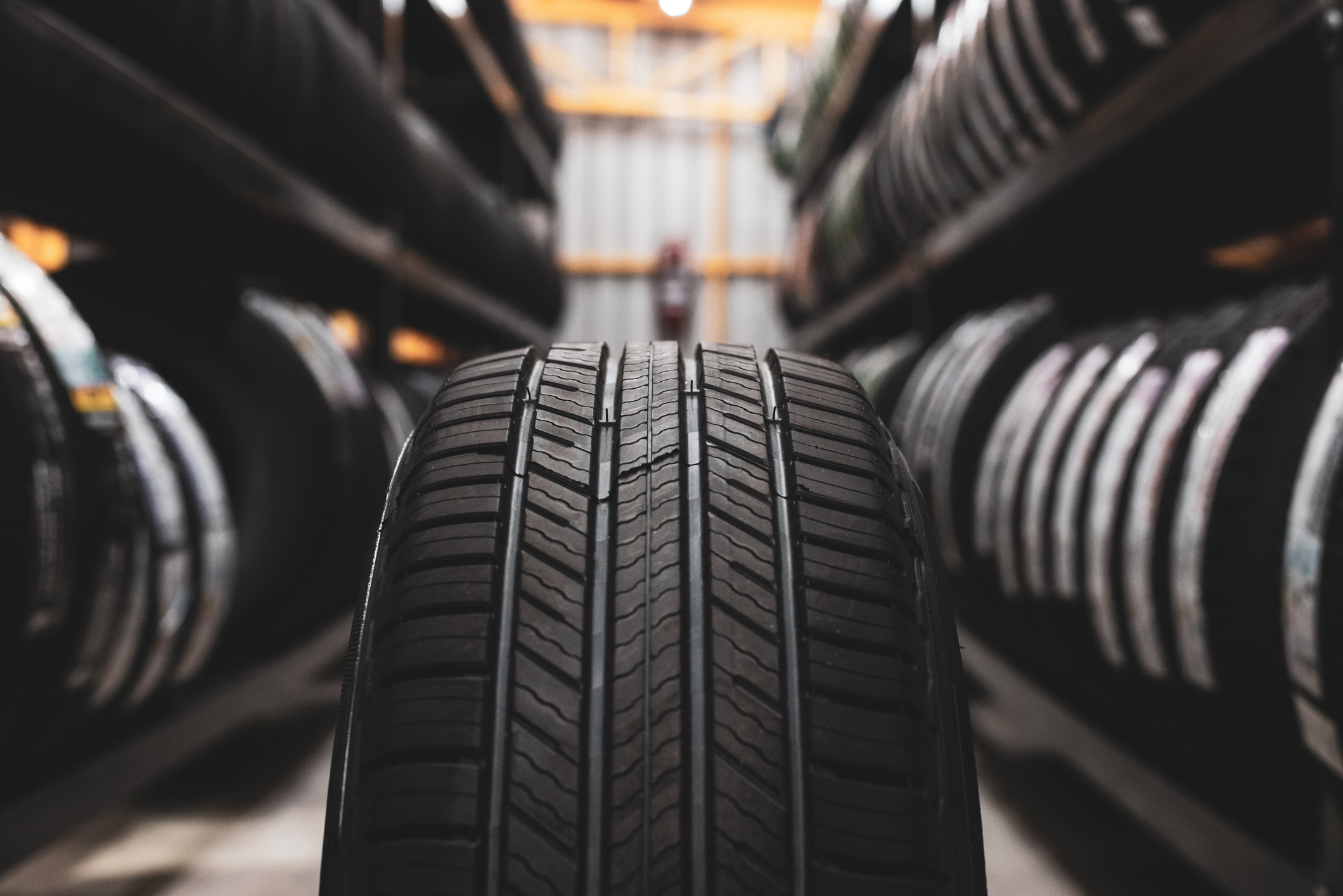 A new tire is placed on the tire storage rack in the car workshop