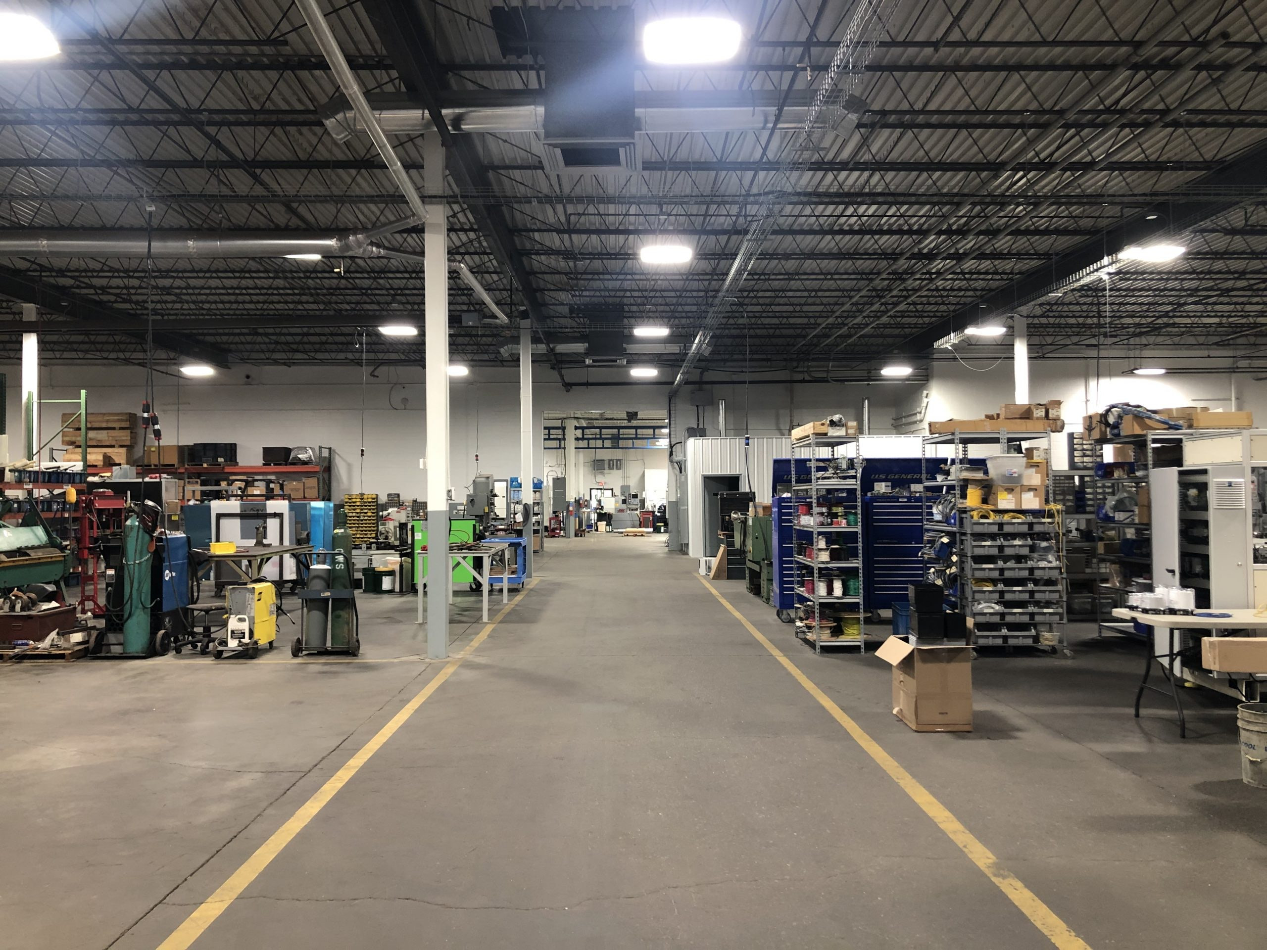 pmi2 facility floor with shelves holding machined parts and components