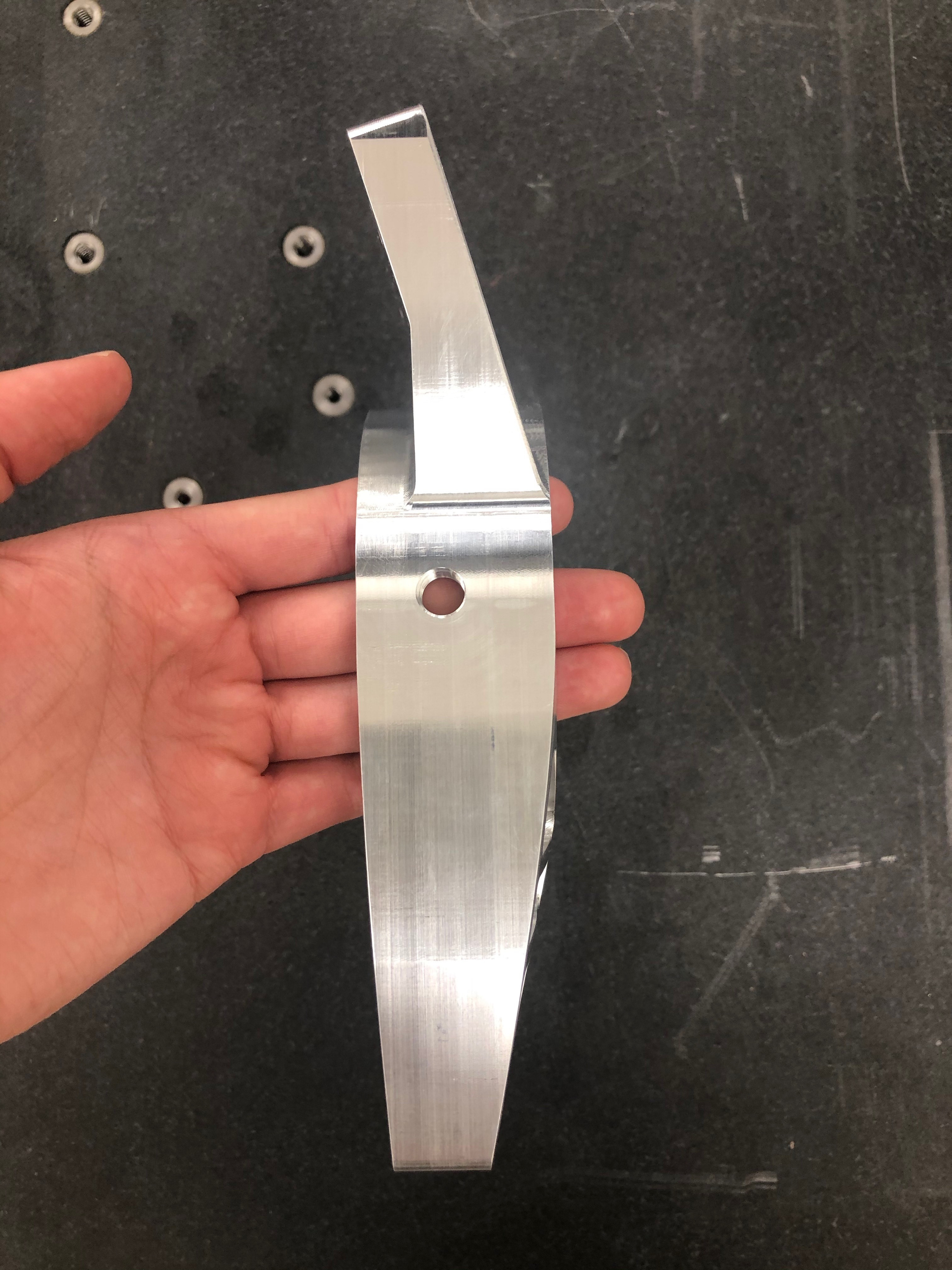 side view of a hand holding a metal part